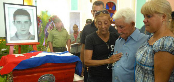Miguel Cejas (CD), padre de Jesús Cejas Árias, víctima de la operación cóndor durante la dictadura militar en Argentina, junto a dos de sus hijas, en el palacio de la ciudad de Pinar del Río, lugar donde se encuentran expuestos los restos de su hijo, el 2 de julio de 2013. Foto: Abel Padrón Padilla