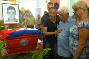 Miguel Cejas (CD), padre de Jesús Cejas Árias, víctima de la operación cóndor durante la dictadura militar en Argentina, junto a dos de sus hijas, en el palacio de la ciudad de Pinar del Río, lugar donde se encuentran expuestos los restos de su hijo, el 2 de julio de 2013. Foto: Abel Padrón Padilla