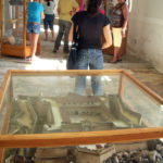 En primer plano, la maqueta del castillo estilo medieval, cuadrado y abaluartado. Su construcción concluyó en 1745, pero en 1762 fue incendiado para que no pudiera ser empleado en la toma de La Habana por los ingleses. Años después fue empleada como prisión y eso requirió que se le hicieran transformaciones constructivas que han sido respetadas en la reconstrucción.