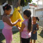 Niños colocando una cinta amarilla en el tronco del árbol por la libertad los héroes cubanos. Foto: Agustín Borrego