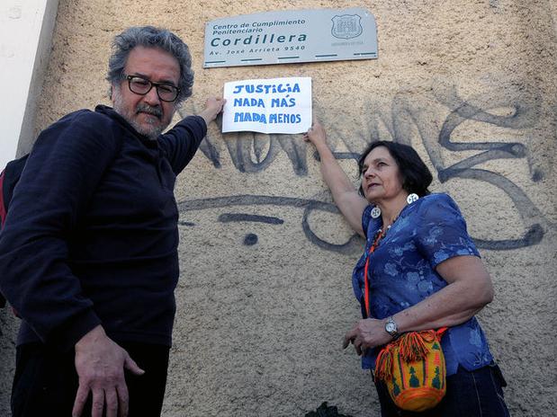Claudio Escobar junto a Olaya Mac-Clure, se manifiestan en las afueras del Penal Cordillera, que se encuentra ubicado en la comuna de La Reina y donde están presos una decena de condenados por violaciones a los derechos humanos. Ambos protestaban ante el anuncio de que se iba a efectuar una cena en honor de Miguel Krassnoff, uno de los sentenciados. Foto: UPI