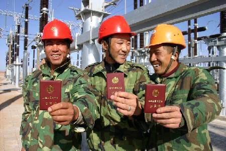 Los sindicatos ejercen un importante papel en la protección de los derechos e intereses de los obreros. En la foto, trabajadores inmigrados enseñando sus carnets de miembro de sindicato. Foto: China.org.cn
