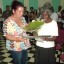 Leonor Somonte (a la derecha) recibe el reconocimiento entregado por Idalmis Gil, primera secretaria del comité municipal del Partido Comunista de Cuba en Ciro Redondo. Foto: José Luis Martínez Alejo.