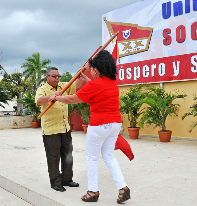 Instante en que Ulises Guilarte entrega la bandera a Bertha Torres, jefa de la delegación. Foto: Nohema Díaz Muñoz
