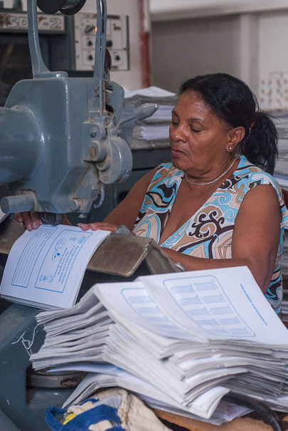 Gladys González presilla diariamente cerca de siete mil u ocho mil libretas manualmente.