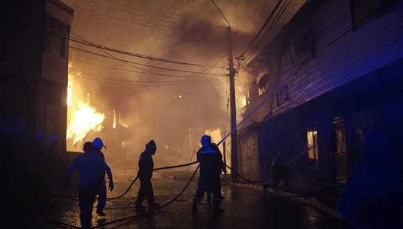 Bomberos intenta controlar un incendio en uno de los cerros de la ciudad de Valparaíso (Chile) . Foto: AP
