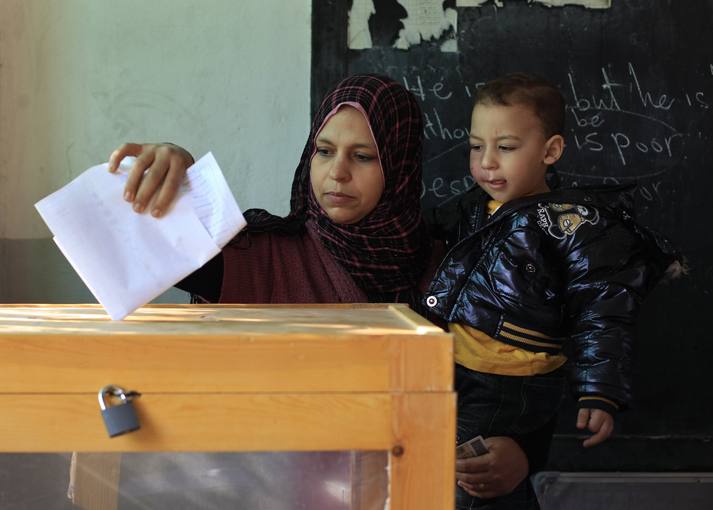 Foto de Archivo An Egyptian woman casts her vote as she holds her son at a polling station during the parliamentary election in Cairo