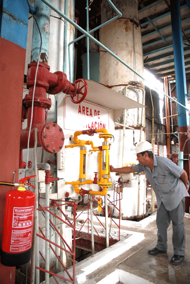 Reynol Gómez observa atento los detalles en las columnas donde se procesa el alcohol. Fotos: Agustín Borrego.