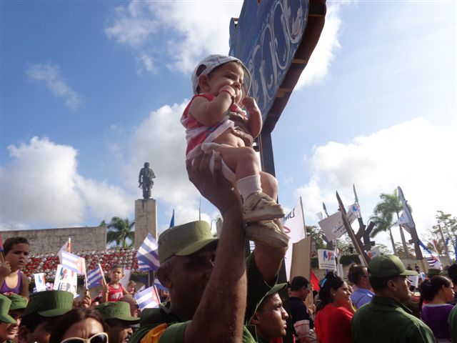 En alto, en los brazos del padre, el futuro que un día querrá igualarse al Che
