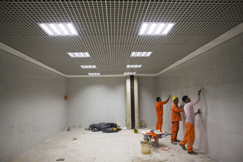 Trabajadores ponen los azulejos en una pared en el Aeropuerto Internacional Tancredo Neves, antes de la Copa del Mundo de 2014 en Belo Horizonte, Brasil, el 9 de junio de 2014. Foto: AP Photo / Victor R. Caivano.