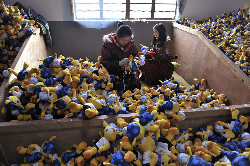 Trabajadores hacen muñecos de peluche de Fuleco El Armadillo, la mascota oficial de la Copa Mundial de la FIFA 2014, en una fábrica en Tianchang, provincia de Anhui, China, el 6 de enero de 2014.  Foto: Reuters / Stringer.