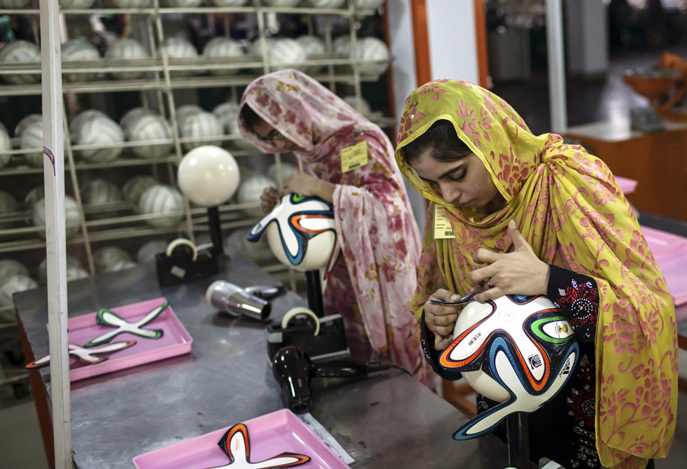 Un empleada ajusta los paneles exteriores en un balón de fútbol dentro de la fábrica balón de fútbol que produce los balones oficiales para la Copa Mundial de 2014 en Brasil, en Sialkot, provincia de Punjab, Pakistán, el 16 de mayo de 2014. Cuando el propietario de la fábrica de Pakistán Khawaja Akhtar sintió el rugido de la multitud en el Mundial de 2006 en Alemania se estableció una meta: fabricar el balón dl mayor torneo de fútbol del planeta. El año pasado finalmente obtuvo su oportunidad -pero sólo 33 días para hacerla posible. Foto: Reuters / Sara Farid.