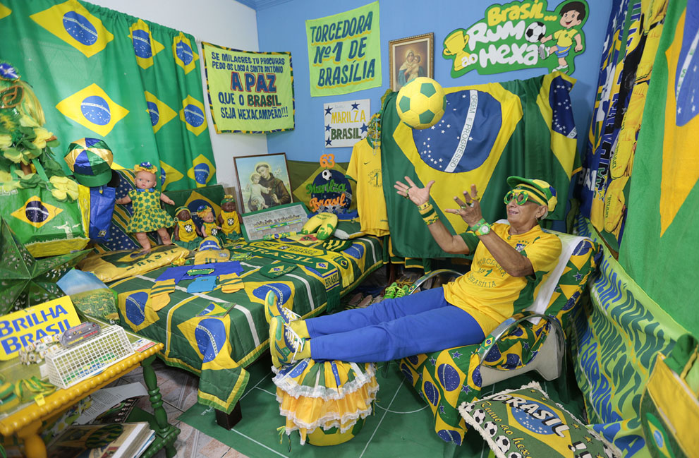 La aficionada brasileña Marilza Guimaraes da Silva, de 63 años, juega con una pelota, vestida con uno de sus muchos trajes a juego con los colores de la bandera nacional del Brasil en su casa en Brasilia el 27 de mayo de 2014. Foto: Reuters / Joedson Alves.