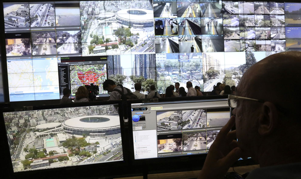 Un policía observa unas pantallas que muestran el estadio Maracaná durante una visita de la prensa al centro de seguridad para la Copa Mundial 2014 en Río de Janeiro el 22 de enero de 2014. Foto: Reuters/Marcelo Regua.