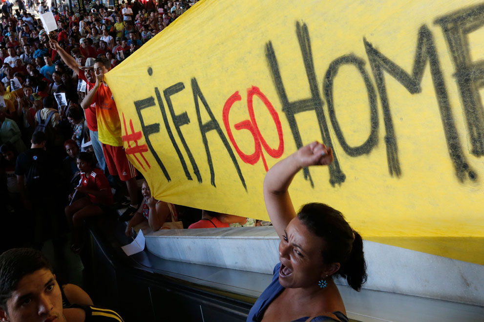 Un manifestante grita consignas contra la FIFA durante una protesta contra la Copa Mundia de Fútbol 2014, en una estación de ómnibus en Brasilia, Brasil, el 27 de mayo de 2014. Muchos brasileños protestan contra las enormes sumas gastadas por el gobierno en la Copa del Mundo. Foto: AP Photo/Eraldo Peres.