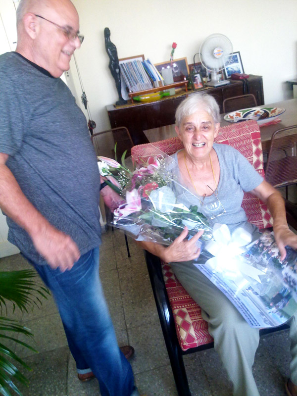 La arquitecta Blanca Hernández,  recibe un ramo de flores de manos de su colega Jorge Cao, amigo entrañable y compañero de labor durante varias décadas .