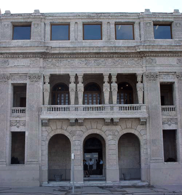 El inmueble de estilo ecléctico que hoy ocupa el Centro Hispano-Americano de Cultura se construyó en 1924 para ser sede de la sociedad de recreo Unión Club, con filiación masculina. Fue ocupado en los primeros años de la década de los 60 por las Brigadas Cobarrubias, integradas por trabajadores de las artes escénicas, que llevaban obras de teatro y espectáculos artísticos a intrincados lugares del país. En los 70 desaparecieron estas brigadas, pero el edifico continuó como sede del Teatro Lírico Nacional. Durante esa década y la siguiente, debido al uso indiscriminado, unido al desgaste por el clima, provocaron su deterioro casi total. En los años 90, la OHC lo incluyó en el llamado Portal de La Habana, y en 1995 se inició su rehabilitación para destinarlo al Centro Cultural de España, bajo los auspicios de la embajada de ese país. Cerró en el 2003, motivado por la hostilidad del Gobierno del presidente José María Aznar contra Cuba. Tras un segundo remozamiento financiado por el Estado cubano, el 10 de mayo del 2004, el Palacio de las Cariátides reabrió sus puertas como sede del Centro Hispano-Americano de Cultura, adscrito a la OHC. Las atrayentes columnas de la Casa de las Cariátides se imponen en la fachada para rememorar la arquitectura clásica griega. Foto: Ubail Zamora, especialista en música del CHAC | fuente: Miriam Montes de Oca Torres, especialista en promoción de actividades culturales.