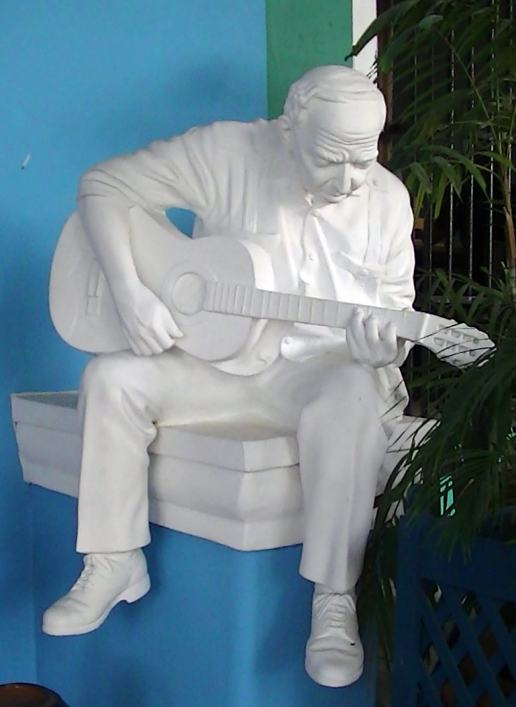 Escultura interactiva (dimensiones variables, escala natural humana, 2001) del artífice Félix Madrigal Echemendía (Sancti Spíritus, 1957) al trovador Rafael Gómez Mayea (Teofilito), instalada en el acogedor Hostal del Rijo, en el centro histórico de la ciudad del Yayabo. Su autor es miembro fundador del Consejo de las Artes Plásticas para el desarrollo de la Escultura Monumental y Ambiental (Codema) en esa provincia. 