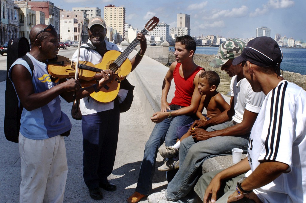 Un grupo de amigos comparten en el malecón habanero.