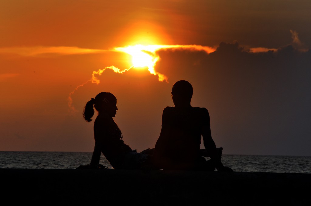 Una pareja de novio disfruta una puesta de sol.