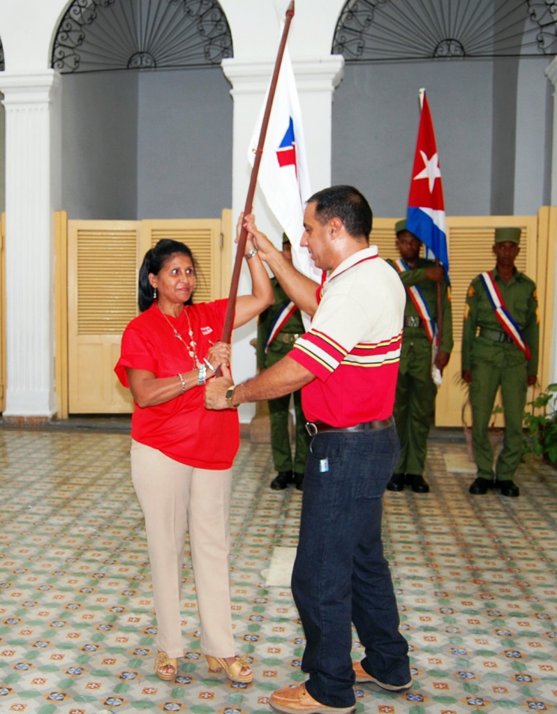 Alfredo Machado López entrega la bandera a Amparo Chongo González, presidenta del buró de la Anir en Cienfuegos y jefa de la delegación de esa provincia.