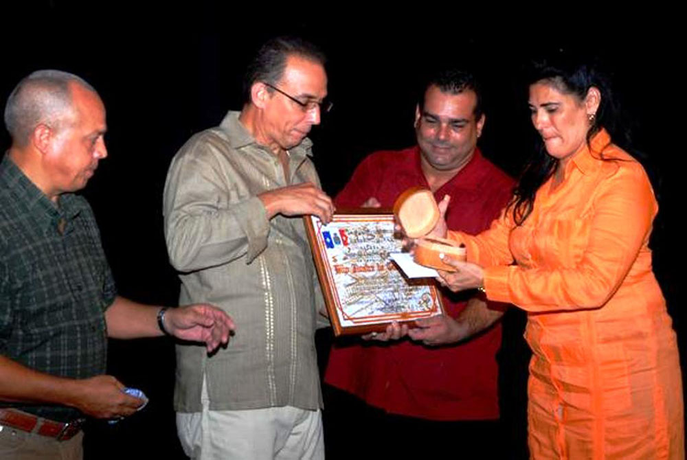 Momento en que Tony Guerrero recibe el certificado de Hijo Ilustre de Cienfuegos y la Roseta de la ciudad. Foto tomada de Internet.