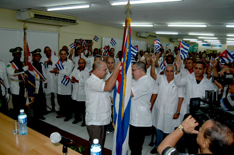 7 de Abril del 2015 Centro de Colaboración ,se despide a la Brigada que parte hacia Nepalen la imágen El Ministro de Salud compañero Roberto Morales hace entrega de la Bandera de la Brigada al jefe del grupo Luis Orlando Olivera detrás los miembros de la ya mencionada Brigada.Fotos: César Rodriguez.