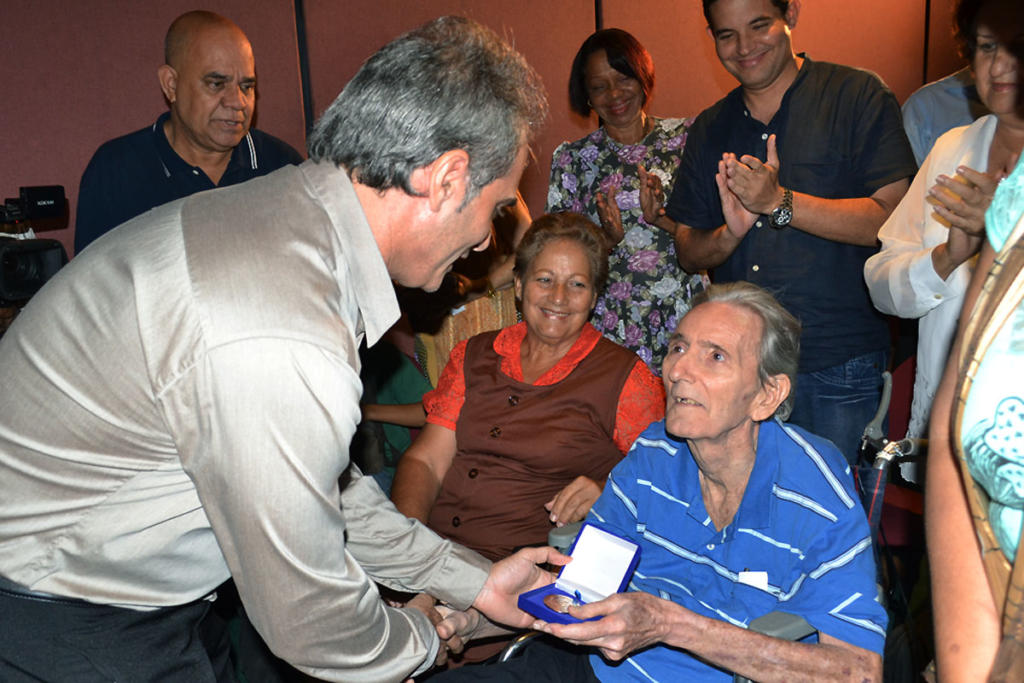 Alberto Núñez Betancourt, director de Trabajadores, entrega Jorge Luis Canela Ciurana, sello conmemorativo por el aniversario 45 de la publicación. Foto: Eddy Martin