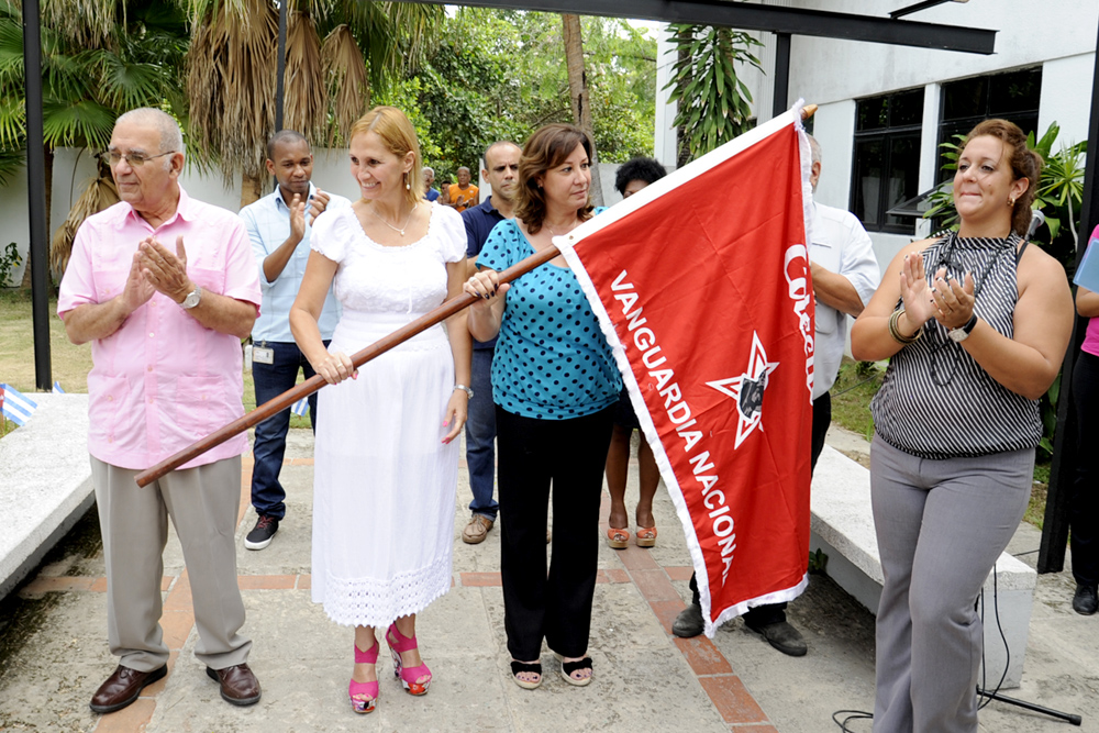Niurka Carlos Pias (vestida de blanco) junto a la secretaria del buró sindical, recibió la bandera de vanguardia nacional. Foto: Roberto Carlos Medina