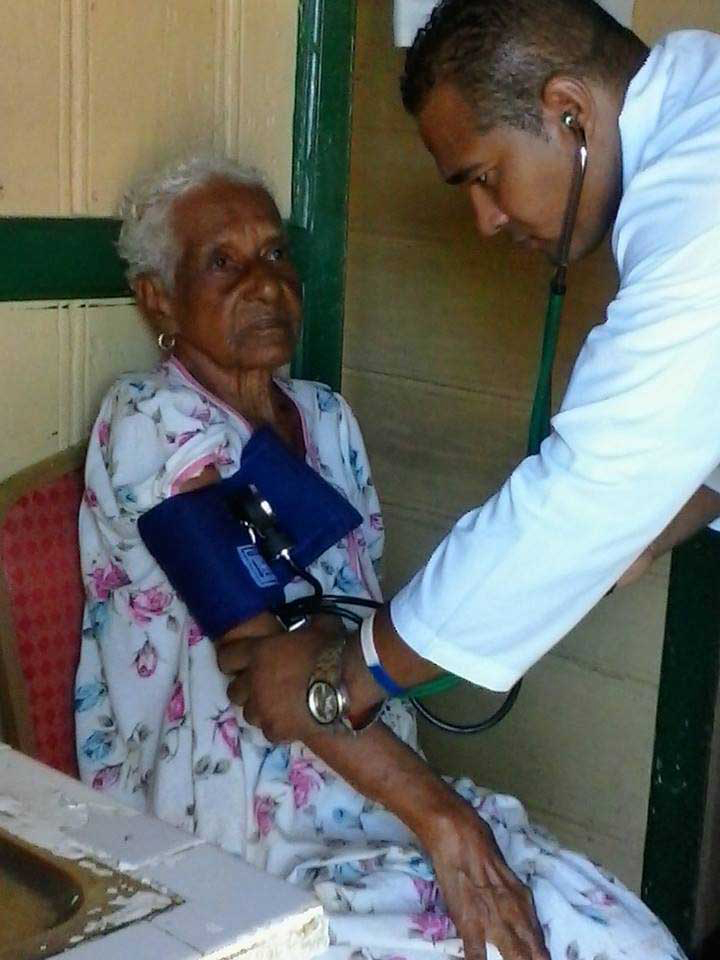 El Dr. Yosvany Vera Jeréz, atiende a una paciente en la zona de Gran Bahía, tras el paso de la tormenta Erika. , en la Mancomunidad de Dominica, el 13 de septiembre de 2015. AIN FOTO/ Cortesía de la Brigada MÉDICA CUBANA/ rrcc