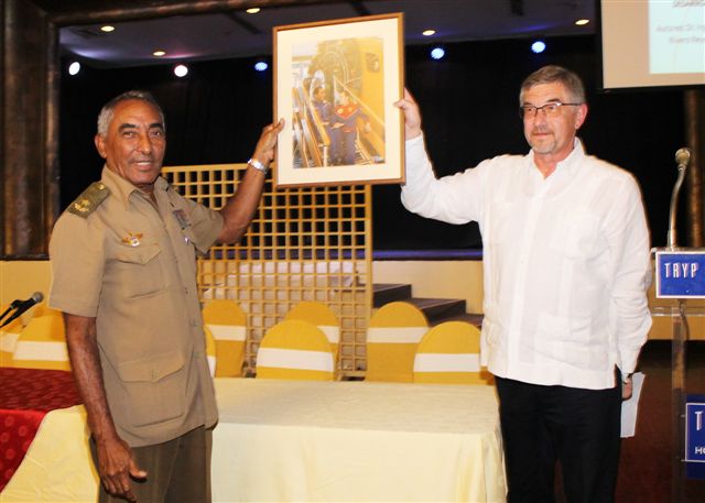 En la sesión conmemorativa por el aniversario 35 del vuelo conjunto Cuba-URSS, el general de brigada, Arnaldo Tamayo Méndez, y primer cosmonauta latinoamericano, recibió una foto donde aparece con su compañero de vuelo Yuri Romanenko, de manos del embajador de Rusia en Cuba, Mijail Kaminin.