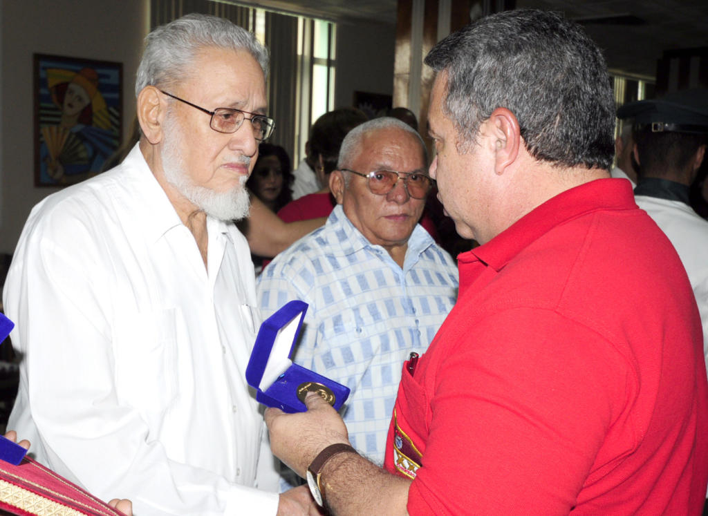 Jorge Risquet (a la izquierda) y Pedro Ross (al centro) reciben el Sello Aniversario 75 de la CTC de manos del secretario general de la central sindical, Ulises Guilarte.  Foto: Roberto Carlos Medina  