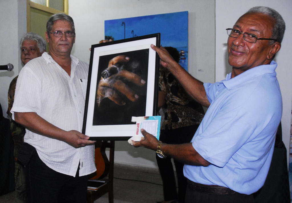 Heriberto Gonzales Brito entrega un cuadro de su autoría a Raimundo Estrada Rodríguez, director del palacio de los Torcedores Palacio de Los Torcedores, Centro Habana. Foto: Agustín Borrego.