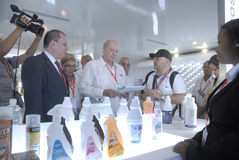 Rodrigo Malmierca Díaz, ministro de Comercio Exterior, dialoga con expositor venezolano sobre el uso de las cocinas de inducción en Cuba. Foto: Agustín Borrego Torres.