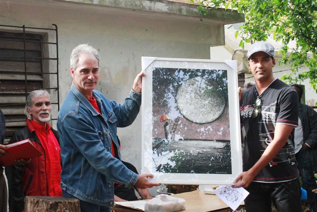 Alberto Núñez Betancourt (a la izquierda), director del periódico Trabajadores, puso una obra de Erik Varela en manos del poeta Néstor Raúl Fernández, de Bayazo, Granma, por su premio de tema social que lleva el nombre del combatiente revolucionario Wilfredo Sánchez.