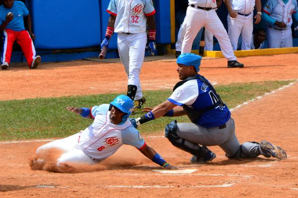 Raúl González y el industrialista Frank Camilo Morejón(azul) en jugada en home de la semifinal entre Ciego de Ávila e Industriales, en el estadio José Ramón Cepero, en Ciego de Ávila. foto: Osvaldo GUTIÉRREZ GÓMEZ