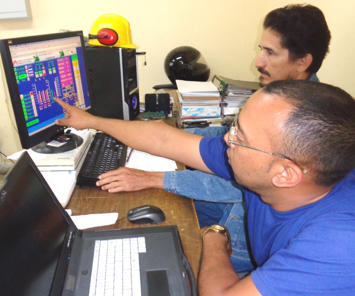 Los ingenieros Yvan Palma (en primer plano) y Gilberto Julio Pérez Cancio manejan el proceso productivo mediante un clic.
