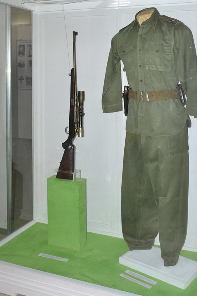 Fusil de mira telescópica similar al empleado durante la guerra de liberación, y uniforme de Comandante en Jefe y zambrán que usó en los primeros años de la Revolución. (Pertenecen, en ese orden, a las colecciones del Museo de la Revolución y de la Oficina de Asuntos Históricos del Consejo de Estado).. Foto: Eddy Martin