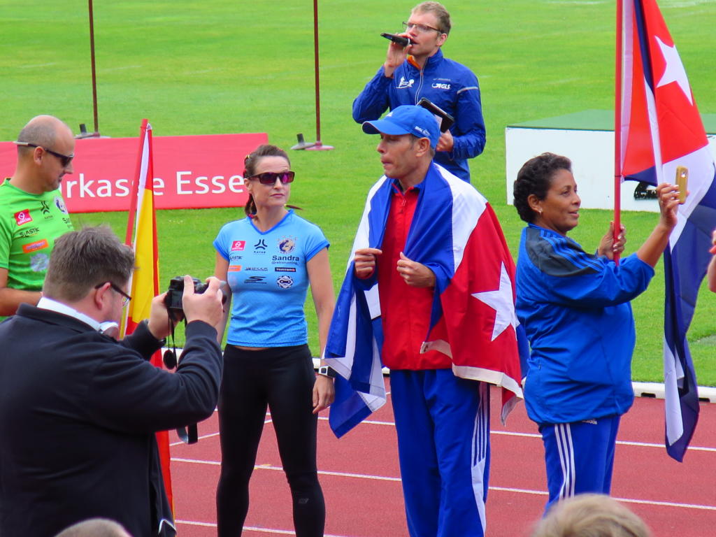 Wilfredo, con la bandera, posando junto a la española Sandra Corcuera (izquierda), varias veces campeona mundial de retrorunning