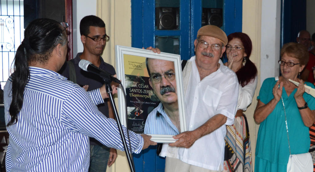 Durante la ceremonia de apertura de la exposición Recuérdame mañana, el presidente de la Uneac en Villa Clara, Antonio Pérez Santos, entregó al artista un diploma de reconocimiento por sus aportes a la cultura cubana.