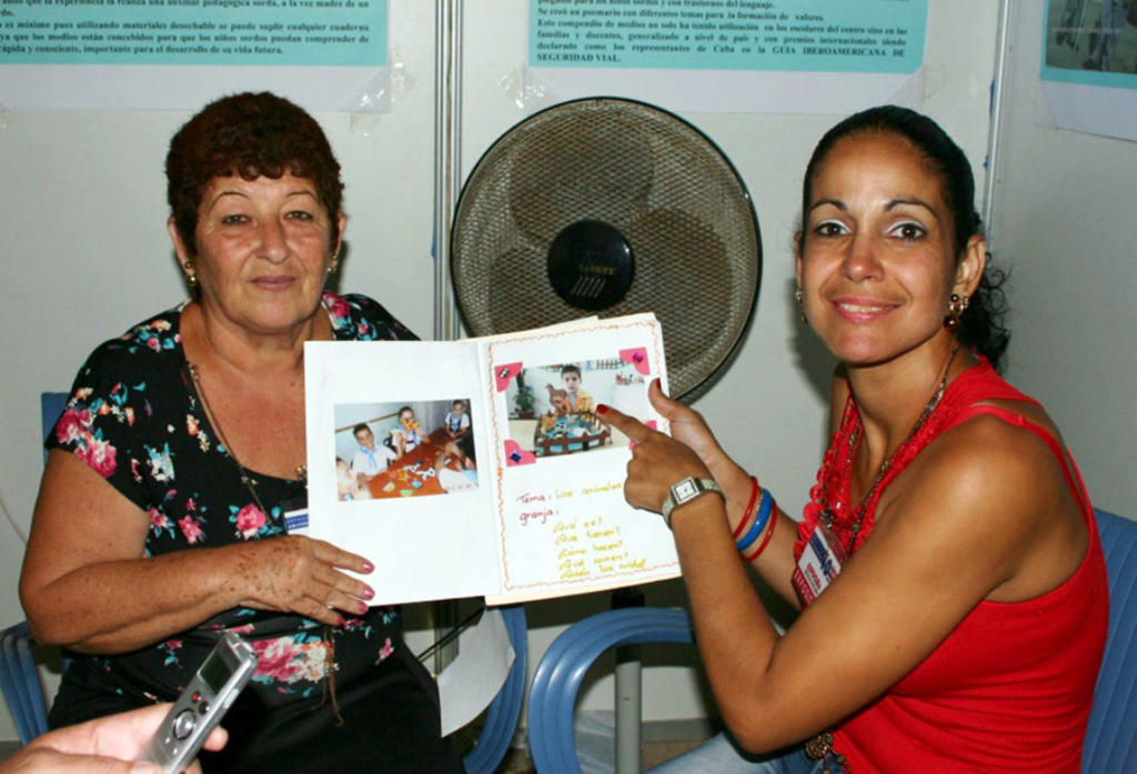 La licenciada Dunierky (a la derecha) muestra una foto de su pequeño hijo de seis años. A la izquierda la máster Marisel Carpio, quien facilitó la entrevista, a través del lenguaje de señas. Foto: César A. Rodríguez