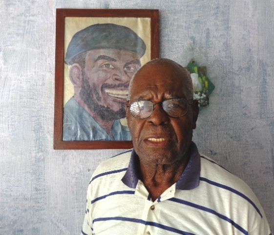 Elmo Bárcenas, junto a un retrato de su hermano Emilio Bárcenas, Tanganica. Foto: Rodny Alcolea