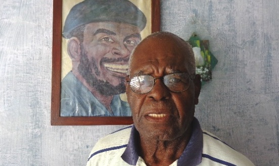 Elmo Bárcenas, junto a un retrato de su hermano Emilio Bárcenas, Tanganica. Foto: Rodny Alcolea