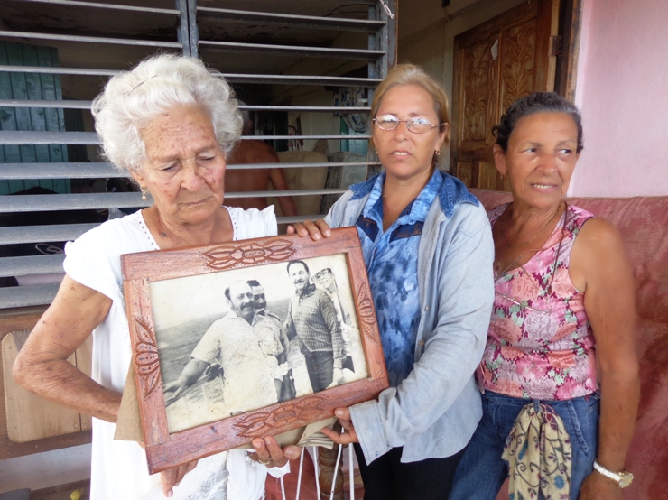 Nieves, la madre, con la foto y sus hijas. Foto: Rodney Alcolea