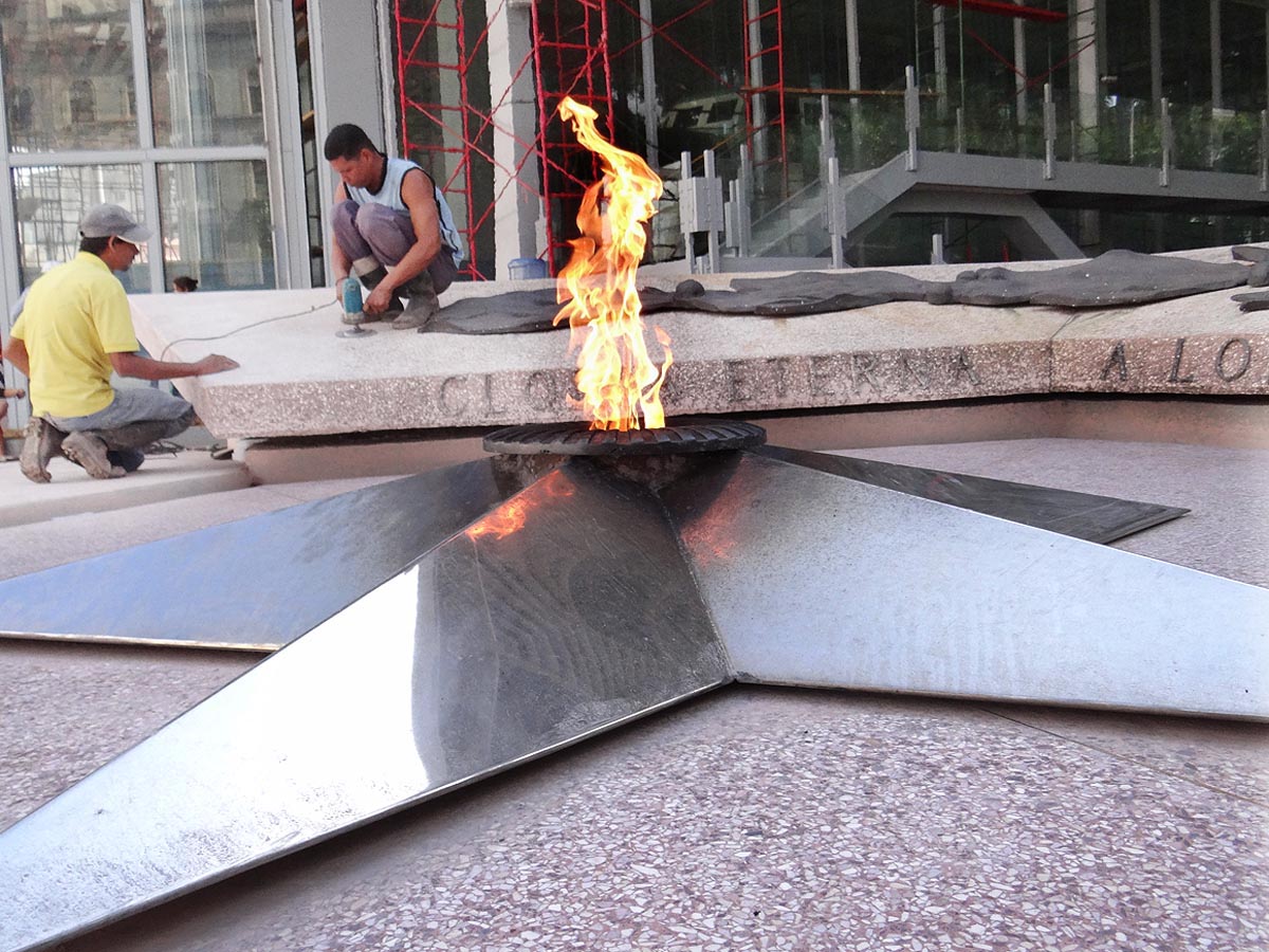 Especialistas en plena labor de renovación del falso techo. Al fondo se aprecia la urna que resguarda la embarcación.