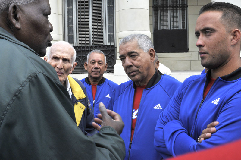 Lazo Y José Ramón Fernández, Presidente del Comité Olímpico Cubano, dialogan con miembros del equipo cubano.