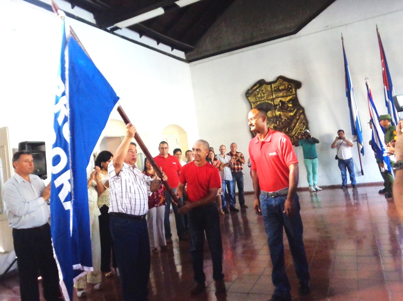 El miembro del Buró Político del Partido y secretario general de la CTC, Ulises Guilarte de Nacimiento, entrega el estandarte. Foto: Jorge Pérez Cruz
