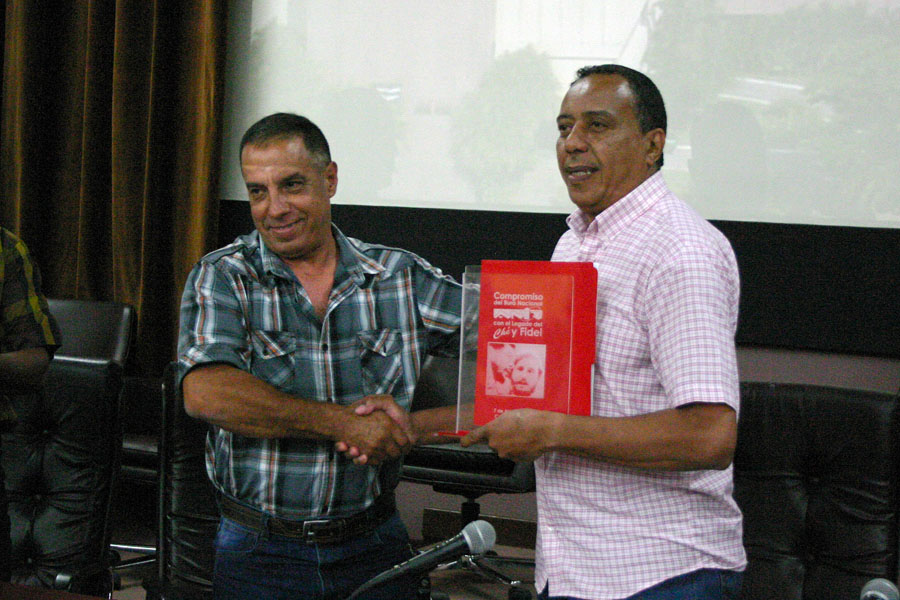 Durante el balance, Alfredo Machado López, presidente de la Anir (a la izquierda) entregó a Ernesto Freire Casañas, jefe de departamento de la Central de Trabajadores de Cuba (CTC) los compromisos productivos y del funcionamiento interno de los territorios con vistas a la rendición de cuentas del movimiento sindical al Secretariado del Comité Central del Partido Comunista de Cuba. Foto: César A. Rodríguez