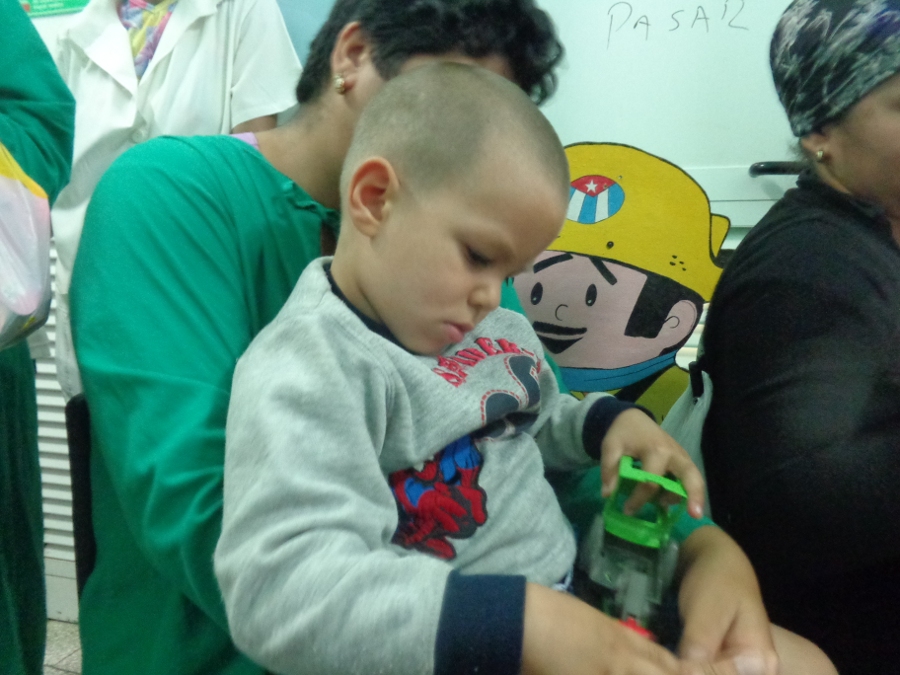 Enel por un rato olvidó los pinchazos y decidió jugar con uno de los juguetes que le regalaron. Foto: Gretel Díaz Montalvo