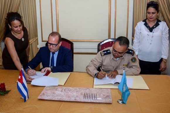 Bob Van Den Berghe (centro, izq.), representante de la oficina de las Naciones Unidas, contra la Droga y el delito y Wiliam Pérez González (centro, der.), vicejefe de la Aduana General de República de Cuba, firman el Memorando de Entendimiento . Foto: Abel padrón Padilla.